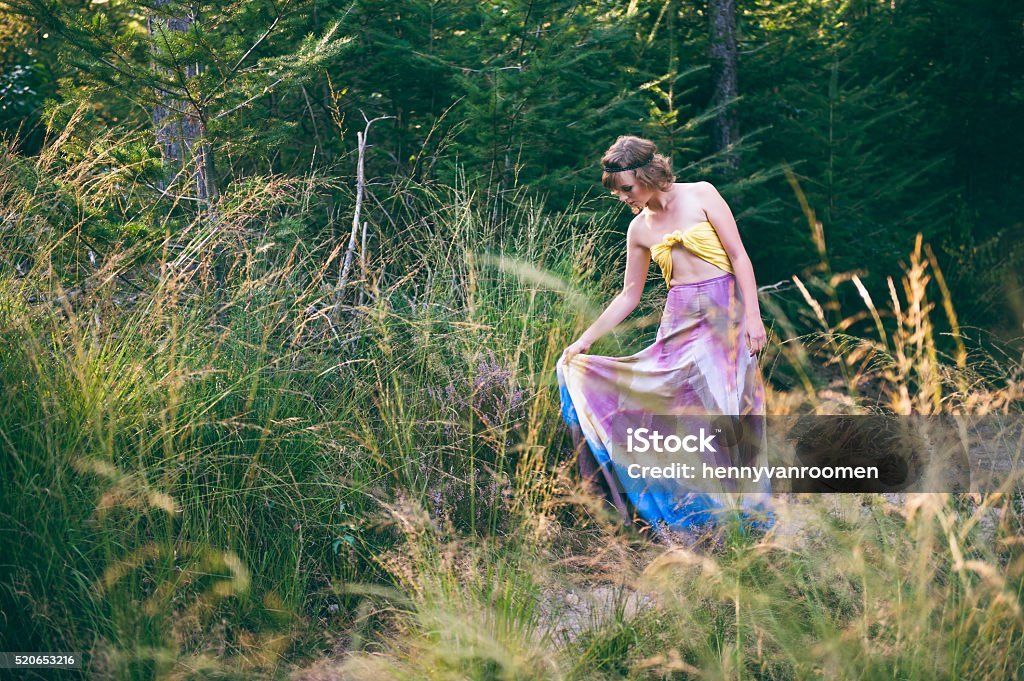 Fashion photo of boho woman wandering in nature Fashion photo of young boho woman wandering in nature and looking at dress 20-24 Years Stock Photo