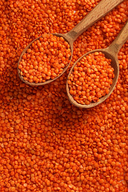 istock Red lentils in the wooden spoons 520653940