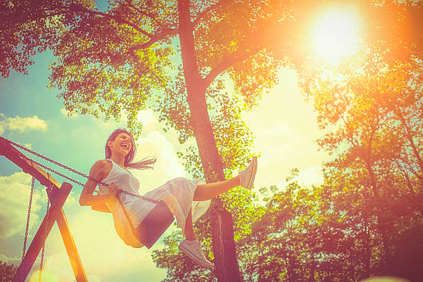 Happy young woman having fun on the swing