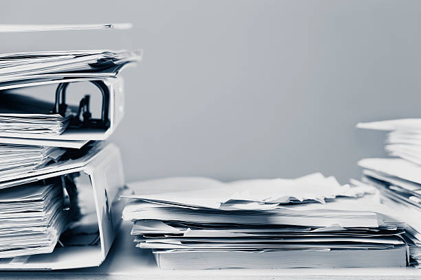 istock messy office desk stack of paper files and magazines 520665619