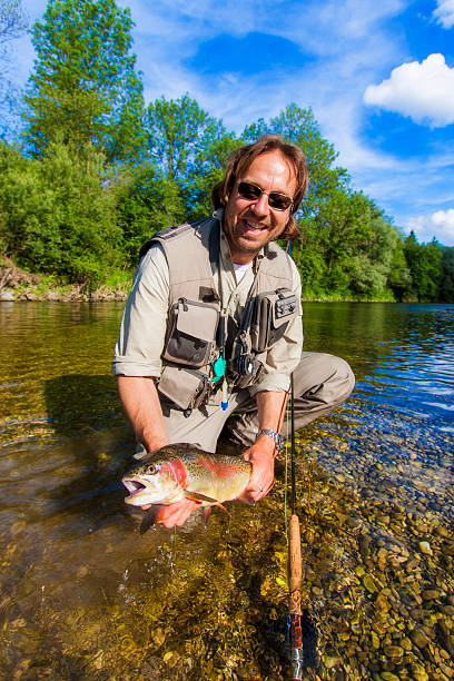istock Flyfisherman holding a rainbow trout 520684687