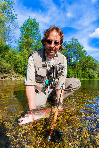 istock Flyfisherman holding a rainbow trout 520684717