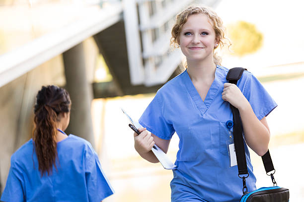 Nursing or medical student walking to class on hospital campus Nursing or medical students walking to class on college campus medical student photos stock pictures, royalty-free photos & images