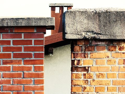 New and old chimney made of red bricks