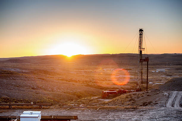 fracking broca de torre de perforación en puesta de sol - oil well fire fotografías e imágenes de stock