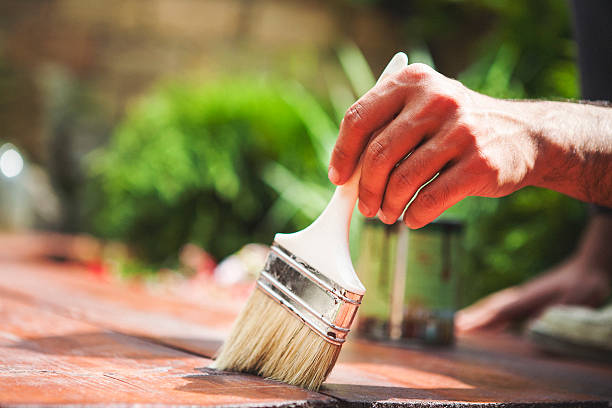 zbliżenie zdjęcie człowiek malarstwo z pędzel do malowania - wood stain paint deck paintbrush zdjęcia i obrazy z banku zdjęć