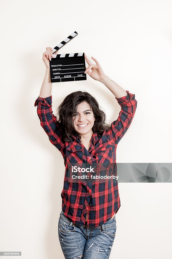 Smiling brunette actress with movie clapper board up Smiling brunette woman actress with movie clapper board up on white background Acting - Performance Stock Photo