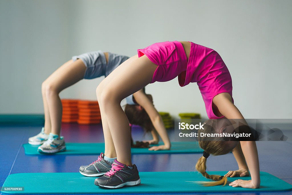 Girls doing gymnastic exercises or exercising in fitness class Girls doing gymnastic exercises or exercising in fitness class. Child Stock Photo