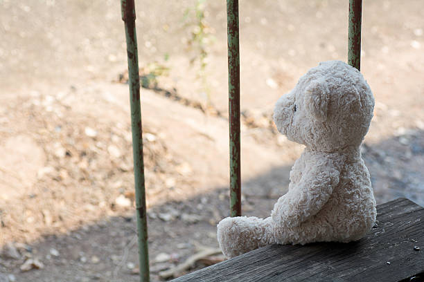 istock Teddy bear sit and waiting  on the wooden stairs. 520701118