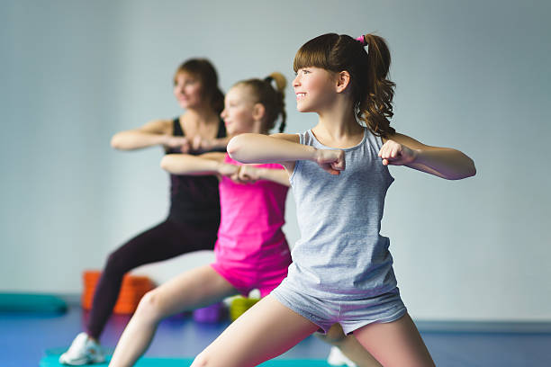Girls and Instructor or mother doing gymnastic exercises  in fitness stock photo