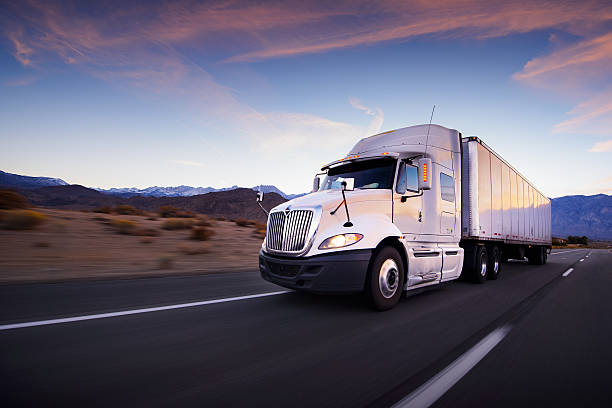 トラックと高速道路でサンセット-交通機関の背景 - commercial land vehicle 写真 ストックフォトと画像