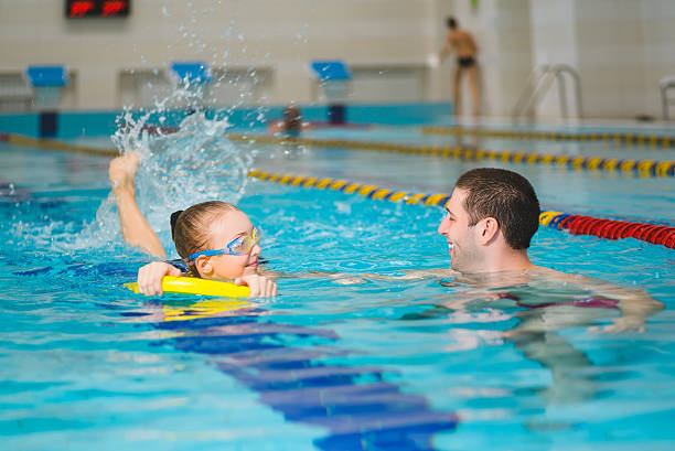 istock instructor teaches the girl swimming in a pool 520703954