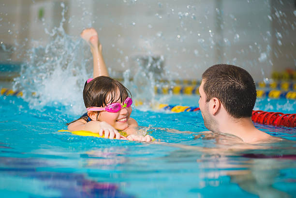 istock instructor teaches the girl swimming in a pool 520704110