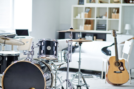 Drum kit and guitars in home rehearsal room