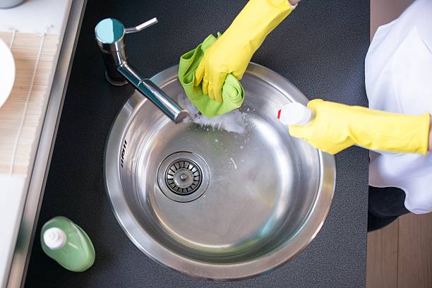 istock Hands in yellow rubber gloves washing the sink 520705286