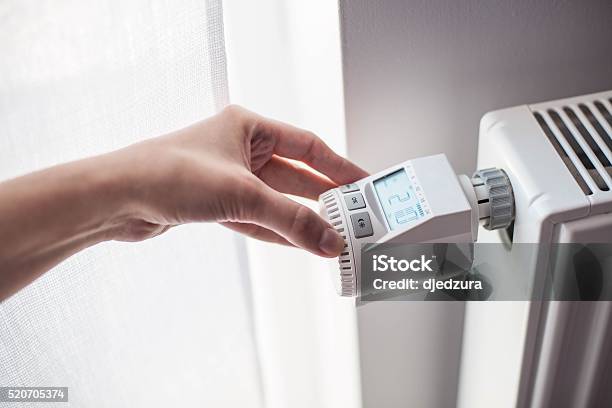 Womans Hand Adjusting Temperature Stock Photo - Download Image Now - Radiator - Heater, Electric Heater, Thermostat
