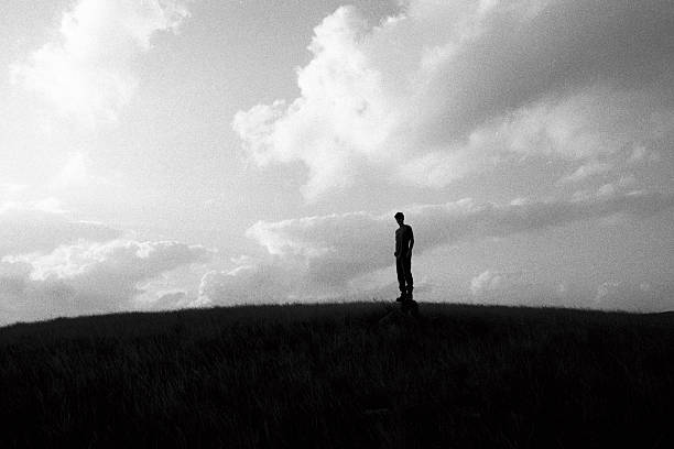 istock Young Man silhouetted on a hill at sunset 520706408
