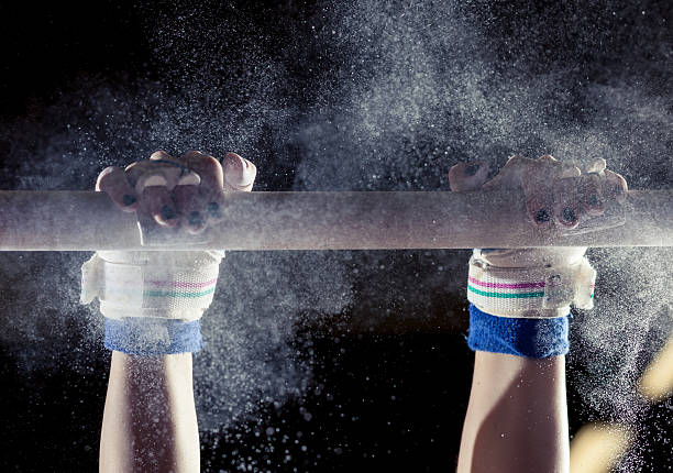 hands of gymnast with chalk on bars stock photo