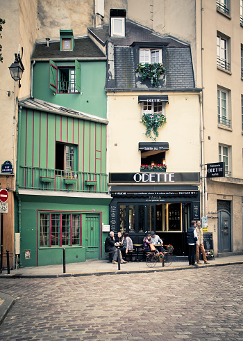 Paris, France - October 9, 2014:   Street scene with old architecture along Saint-Michel Latin Quarter in Paris France with people visible.  This well known and visited district in Paris is bisected by the Boulevard St. Germain and the Boulevard St. Michel.