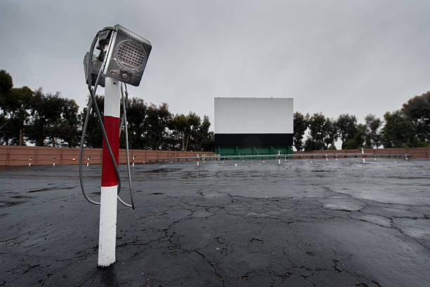 Drive in movie area with screen and speaker poles stock photo