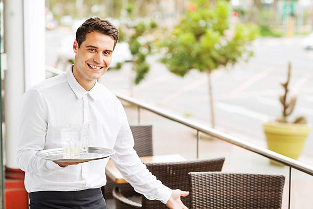 Waiter Holding Serving Tray With Drinks Welcoming In Restaurant