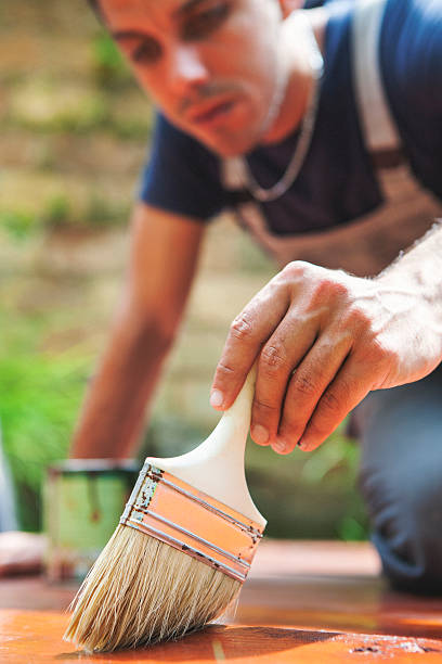 istock Young man painting the deck 520709423