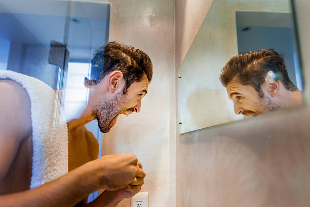 istock Man examining teeth in mirror at bathroom 520709532