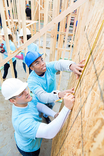 istock Men measure wall in charity home 520712574