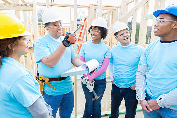 istock Volunteer construction foreman talks to volunteers 520712816