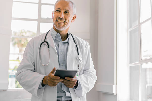 Cheerful doctor holding digital tablet in clinic