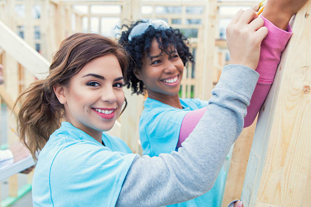 istock Women smile as they work on charity house 520714794
