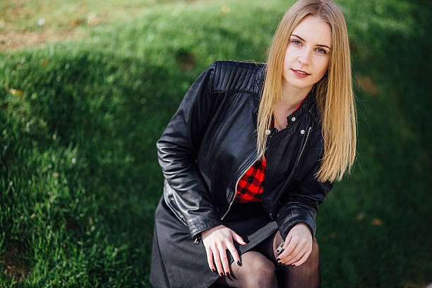 istock Young pretty girl sitting on the grass 520714862
