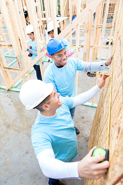 istock Volunteers work together to measure wall at construction site 520715000