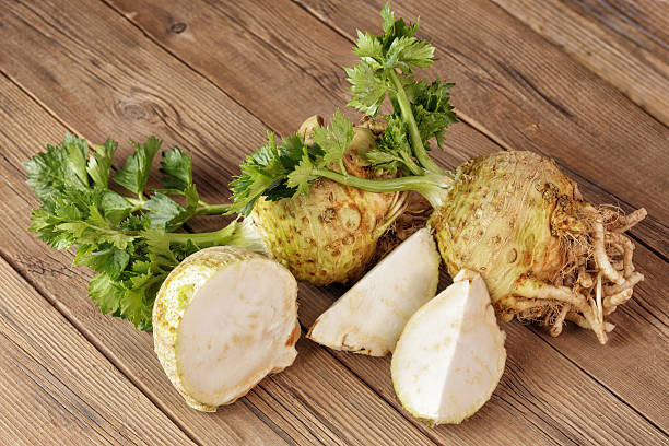 Fresh celery root Fresh celery root on a wooden board, one cut. Celeriac stock pictures, royalty-free photos & images