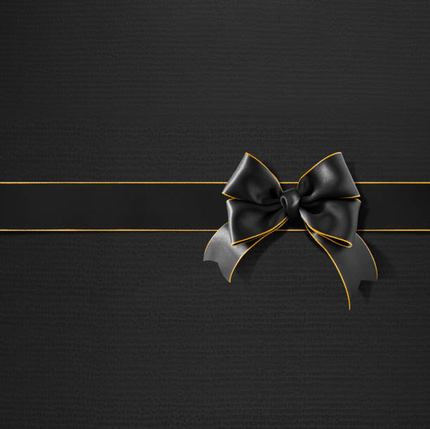 istock Double bow gold rimmed black ribbon on black gift paper 520731249