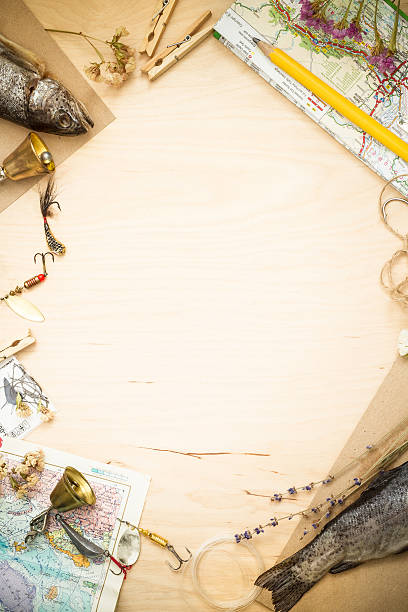 Raw fish and fish hooks on a wooden copy space