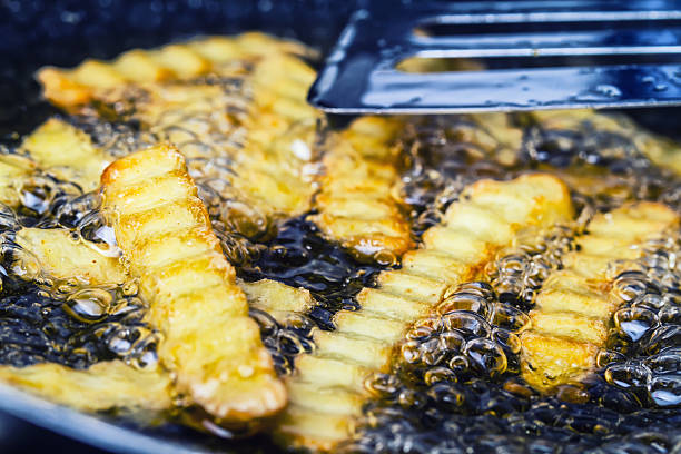 istock Potato chips frying in oil in a pan 520733567