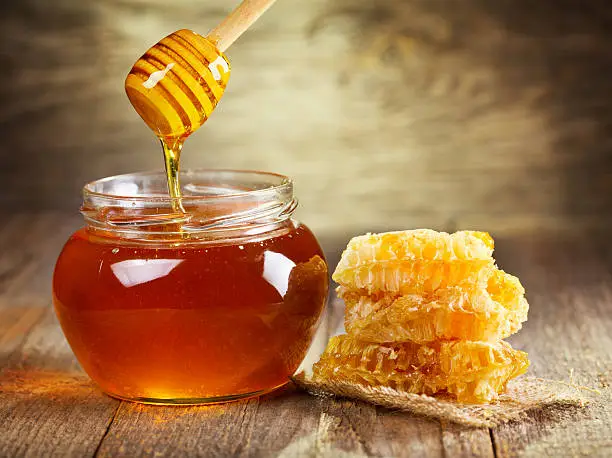 Photo of jar of honey with honeycomb
