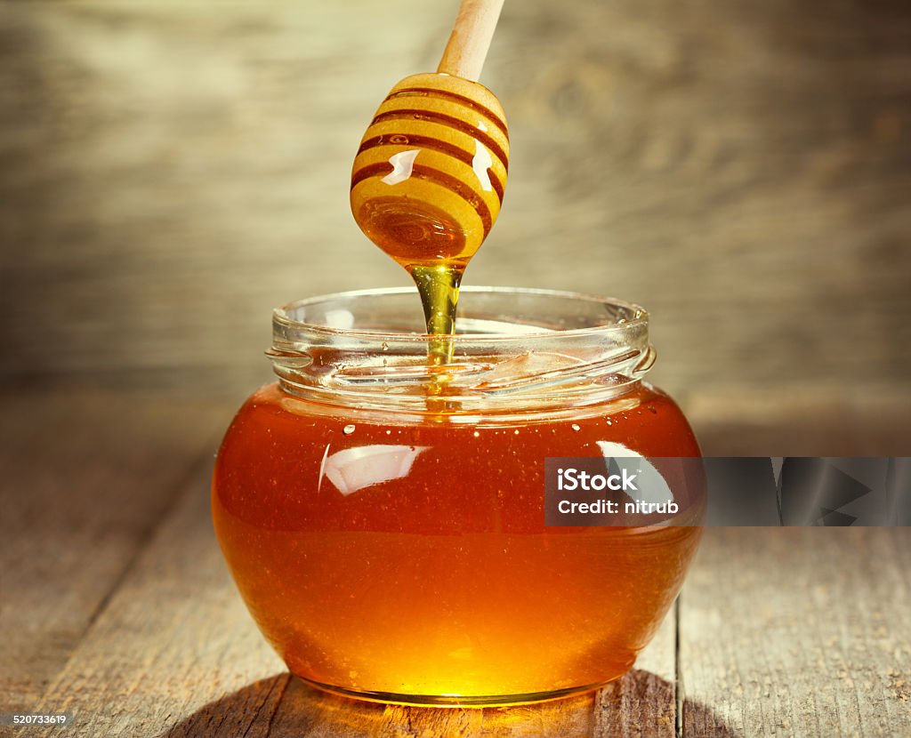 pouring honey Honey pouring into bowl on wooden Honey Stock Photo