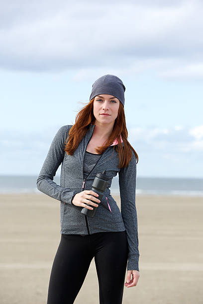 istock Sporty woman standing outdoors with water bottle 520733841