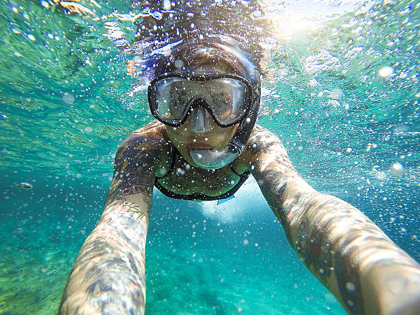 молодая женщина с маской плавательный подводное плавание с дыхательной трубкой - directly below looking women human head стоковые фото и изображения