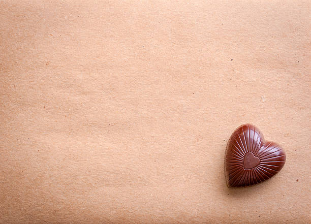 Chocolate heart over old paper stock photo