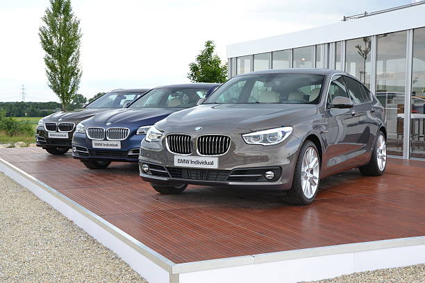 BMW in a row Munich, Germany - July, 5th, 2013. BMW 5 GT and 5-series on the exposition during the international press launch. The 5-series model is one of the most popular vehicles in premium segment. The 5-series model is available with all-wheel-drive system xDrive. bmw dealership stock pictures, royalty-free photos & images