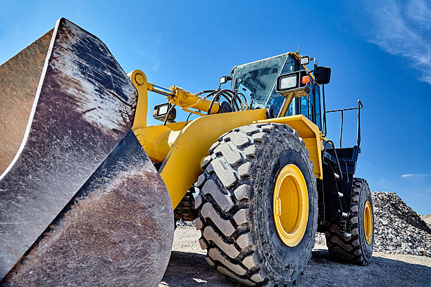 Heavy equipment machine wheel loader on construction jobsite Construction heavy equipment loader and bucket on jobsite construction machinery stock pictures, royalty-free photos & images