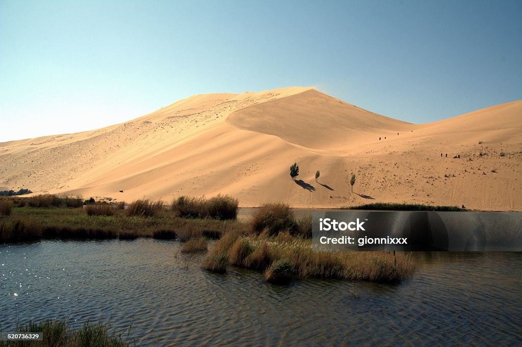 Badain lake, Inner Mongolia China Mystic Badain lake in Badain Jaran desert. This desert is home to some of the tallest stationary dunes on Earth, some reaching a height of more than 500 meters.  Gobi Desert Stock Photo