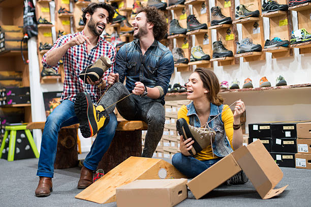 menschen, die spaß im schuhgeschäft - shoe store sales clerk customer stock-fotos und bilder