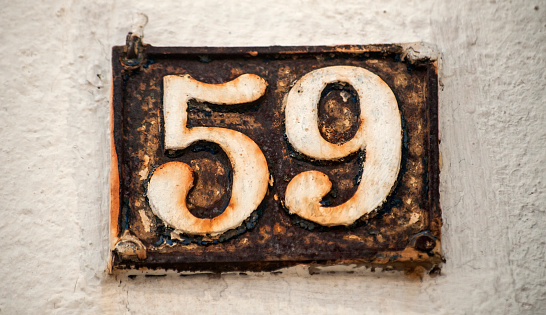 Old retro weathered cast iron plate with number 59