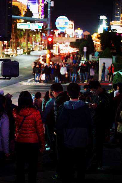 Las Vegas, USA - December 23, 2015: Crowds of tourists are standing at a traffic light on the flashy illuminated Las Vegas Boulevard on the night of December 23, 2015 in Las Vegas.