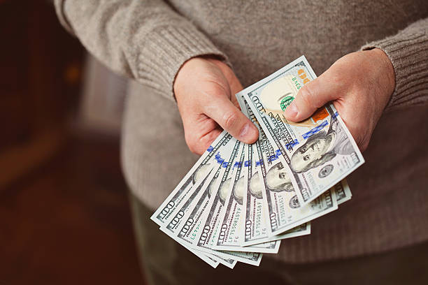 istock dollars in the hands of men 520743756