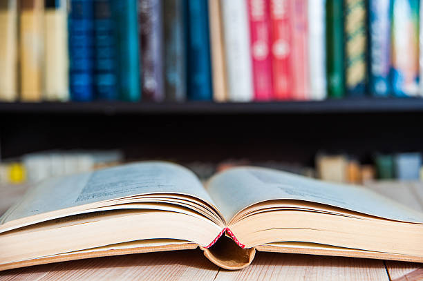 istock Open book, hardback books on  wooden table. Back to school 520743778